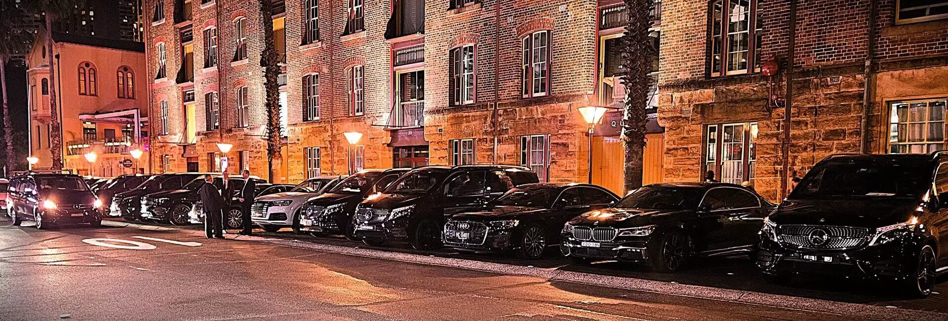 Line of Luema chauffeur vehicles waiting outside a Sydney venue at night